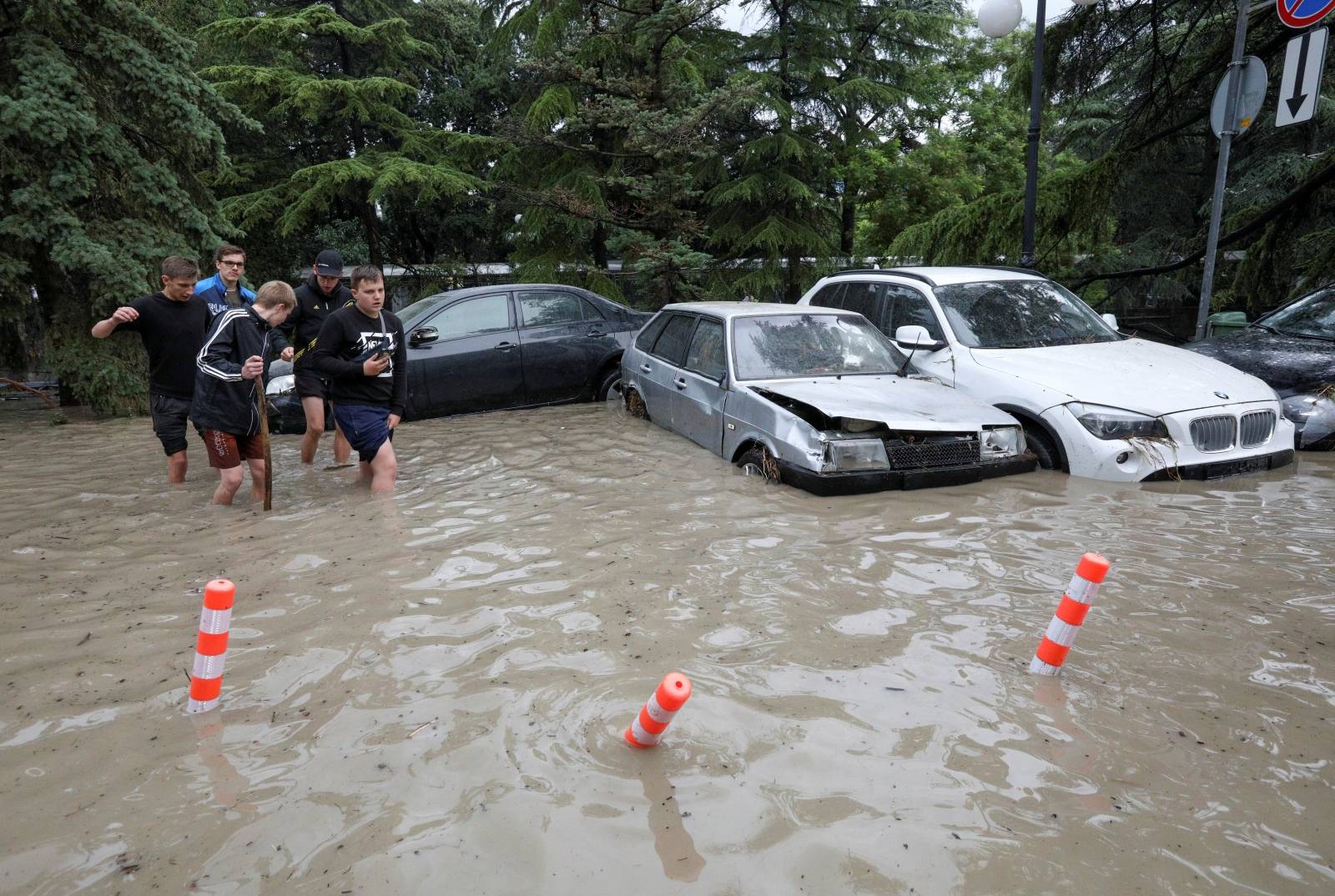 Cars are stuck in deep water in a flooded street following heavy rainfall in Yalta