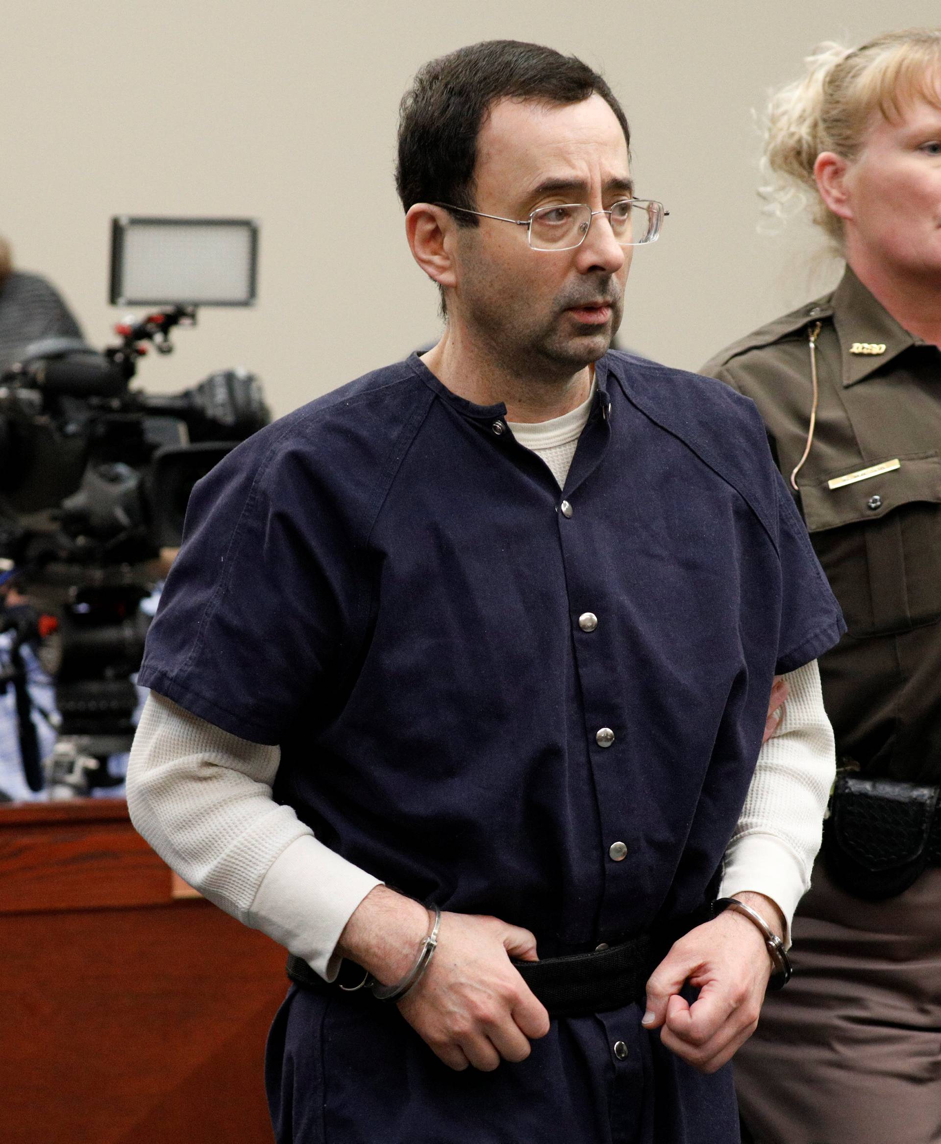 Larry Nassar, a former team USA Gymnastics doctor, who pleaded guilty in November 2017 to sexual assault charges, is led from the courtroom after listening to victim testimony during his sentencing hearing in Lansing, Michigan
