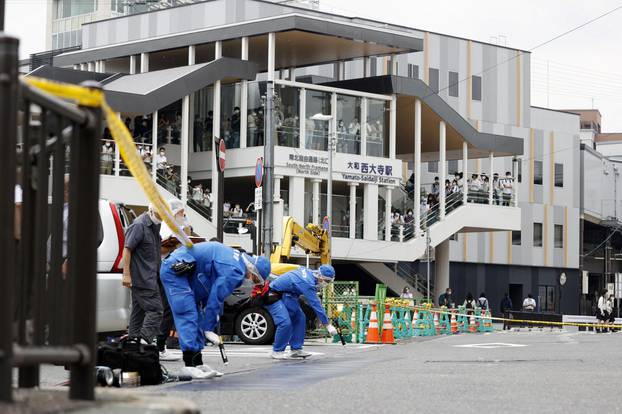 Investigators work around the scene where former Japanese Prime Minister Shinzo Abe was shot from behind by a man in Nara