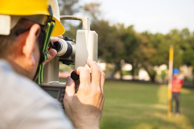 Surveyor,Engineer,With,Partner,Making,Measure,On,The,Field