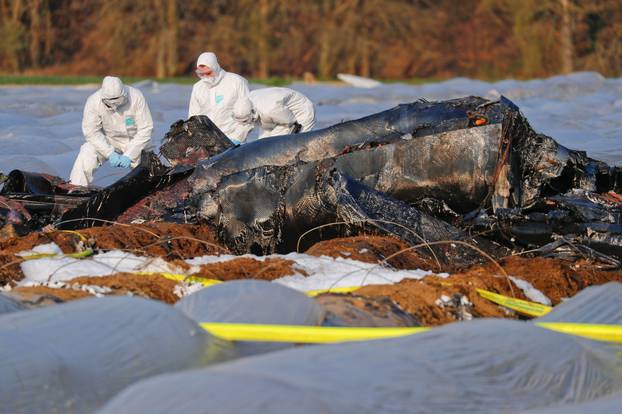 Forensic experts work next to the remains of a small plane that crashed near Erzhausen