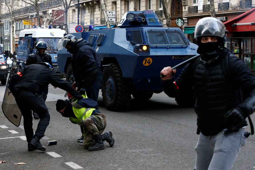 French Gendarmes apprehend a protester wearing a yellow vest during a national day of protest by the "yellow vests" movement in Paris