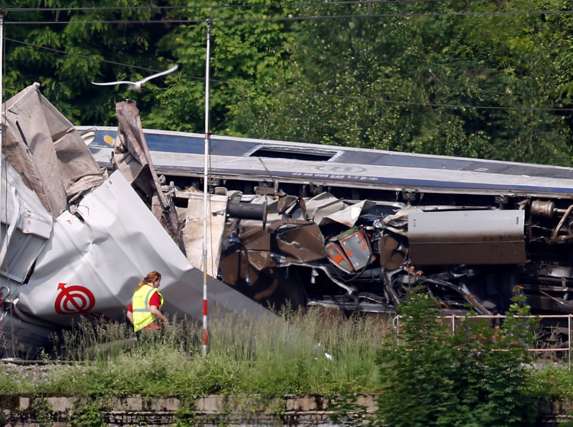 An official inspects the wreckage of a passenger train after it crashed into the back of a freight train in the eastern Belgian municipality of Saint-Georges-Sur-Meuse