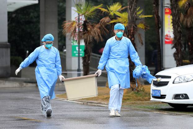 Medical staff carry a box as they walk at the Jinyintan hospital, where the patients with pneumonia caused by the new strain of coronavirus are being treated, in Wuhan