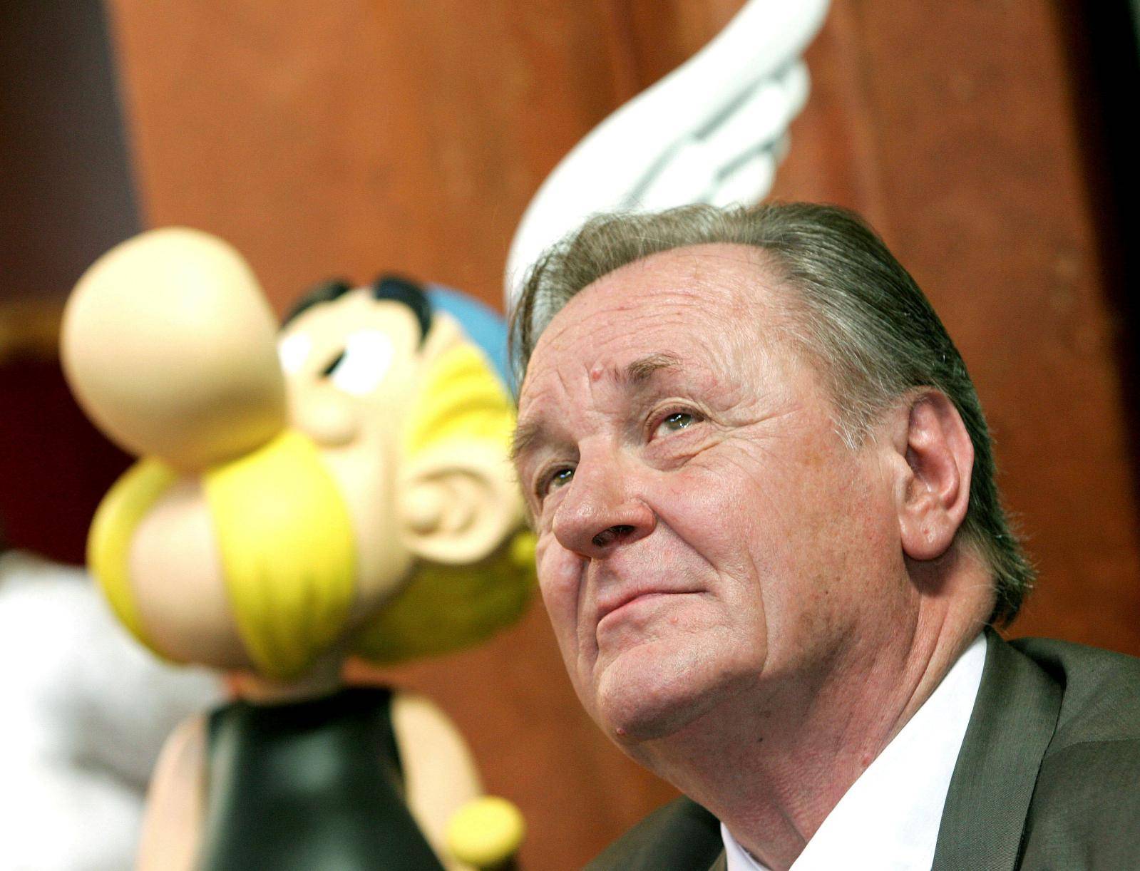 FILE PHOTO: Albert Uderzo, the artist of all thirty-three Asterix adventures and story writer of the last nine books, sits next to a model of Asterix during a news conference in Brussels