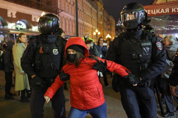 Russian police officers detain a protester during an unsanctioned rally in Moscow