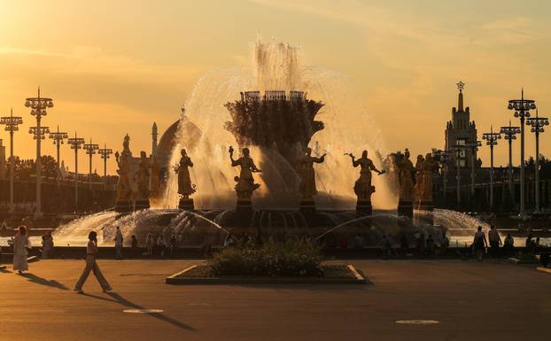 People enjoy the evening next to a fountain after a hot day at the Exhibition of Achievements of National Economy (VDNH) in Moscow
