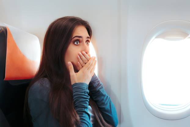 Woman Sitting By the Window on An Airplane Feeling Sick