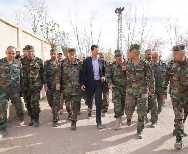 Syrian President Bashar al-Assad walks with Syrian army soldiers in eastern Ghouta