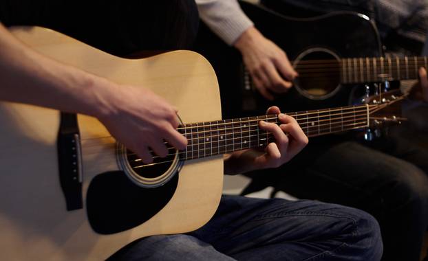 Two people duet playing a melody on guitars 