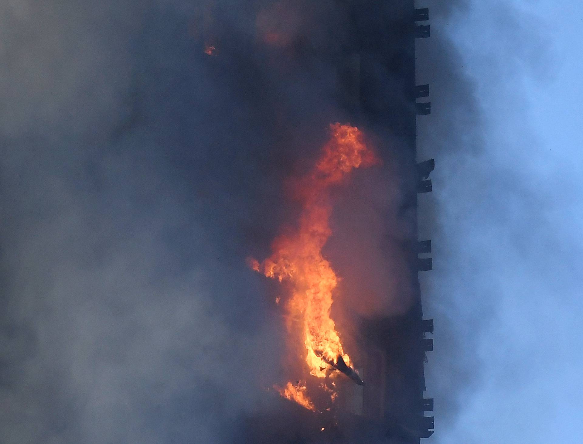 Flames and smoke billow as firefighters deal with a serious fire in a tower block at Latimer Road in West London