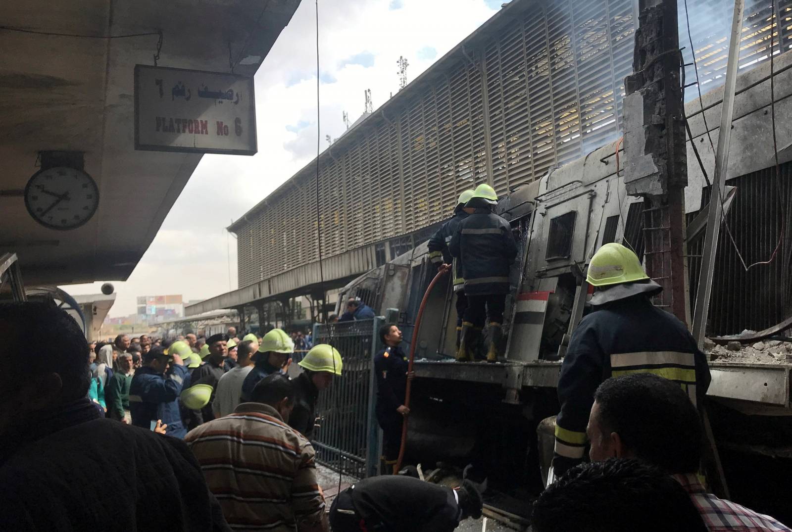 Rescue workers and people are seen after a fire caused deaths and injuries at the main train station in Cairo