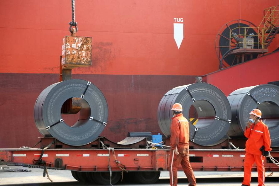 FILE PHOTO: Workers load steel products for export to a cargo ship at a port in Lianyungang