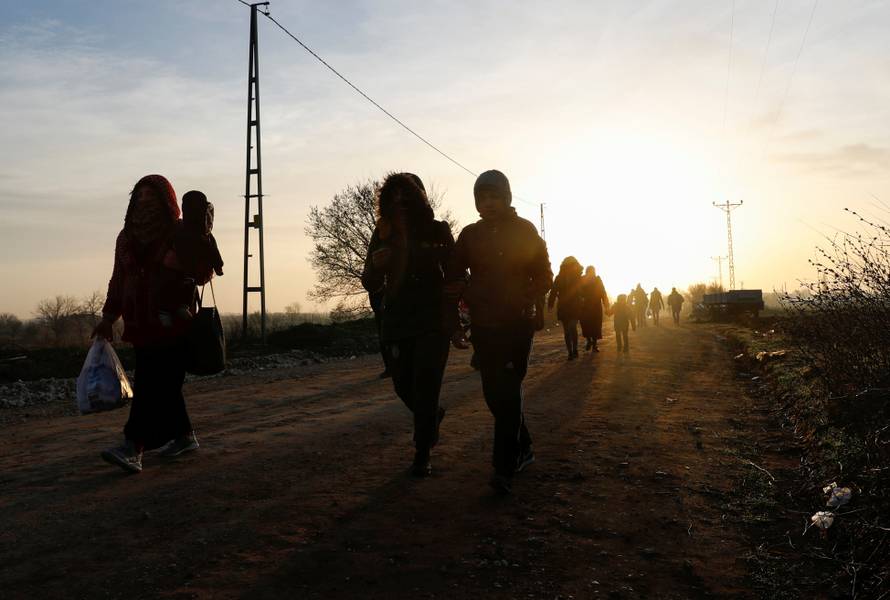 Migrants walk next to the Turkey's Pazarkule border crossing with Greece's Kastanies, near Edirne