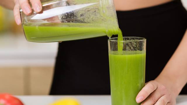 Healthy eating. Woman pouring detox shake to glass