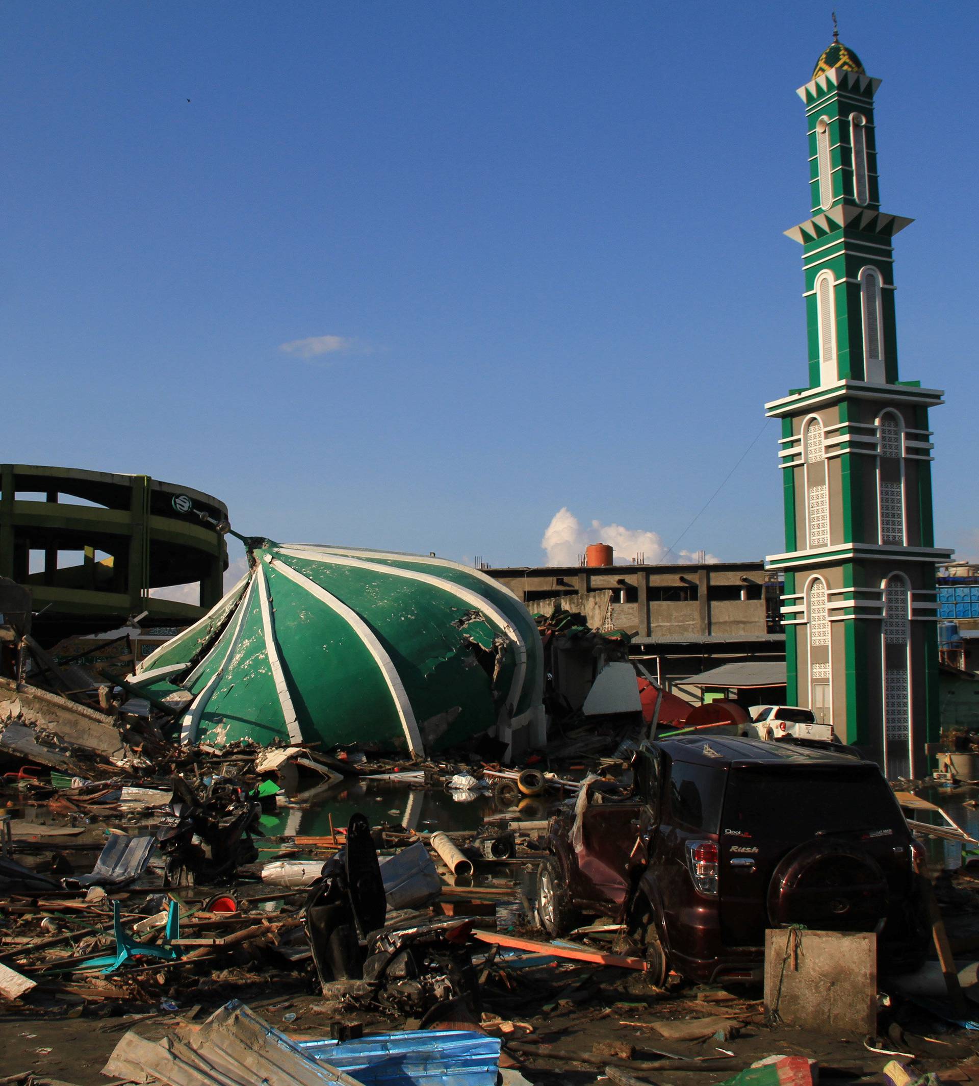 Residents walk near Baiturrahman mosque which was hit by an earthquake and tsunami in Palu