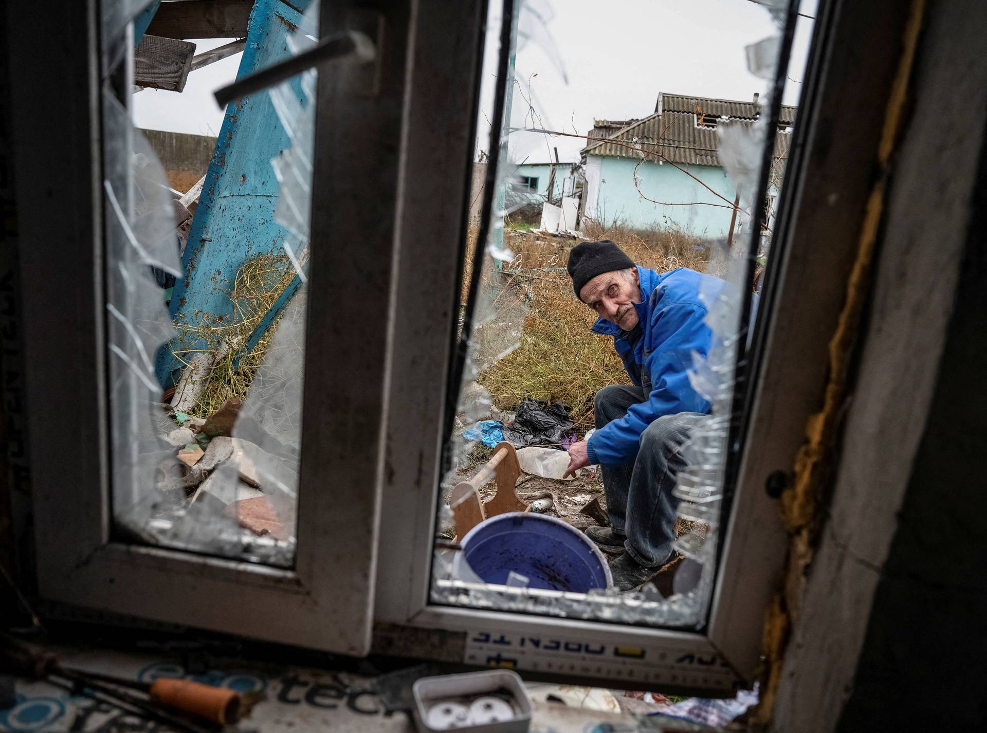 Mykhailo, 65, a local resident, repairs his destroyed house in the village of Pokrovskii Posad