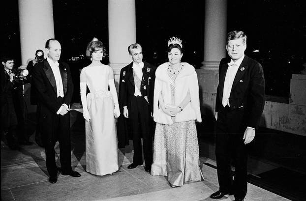 Mohammad Reza Pahlavi, the Shahanshah of Iran, and his wife, Empress Farah Pahlavi, arrive at the White House for a state dinner in their honor on April 11, 1962. They are greeted by Chief of Protocol Angier Biddle Duke, First Lady Jacqueline Kennedy, and