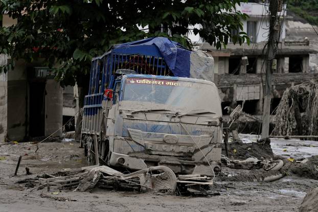 A vehicle is covered with mud following a flash flood at Trishuli, Nepal