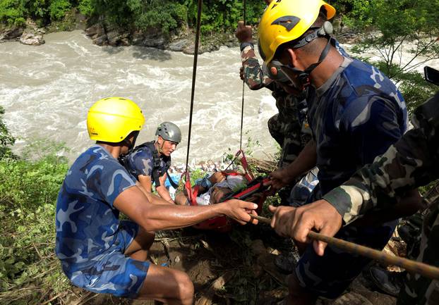 Security force personnel work to rescue injured passengers after a bus carrying Indian passengers traveling to Kathmandu from Pokhara plunged into a river in Tanahun District