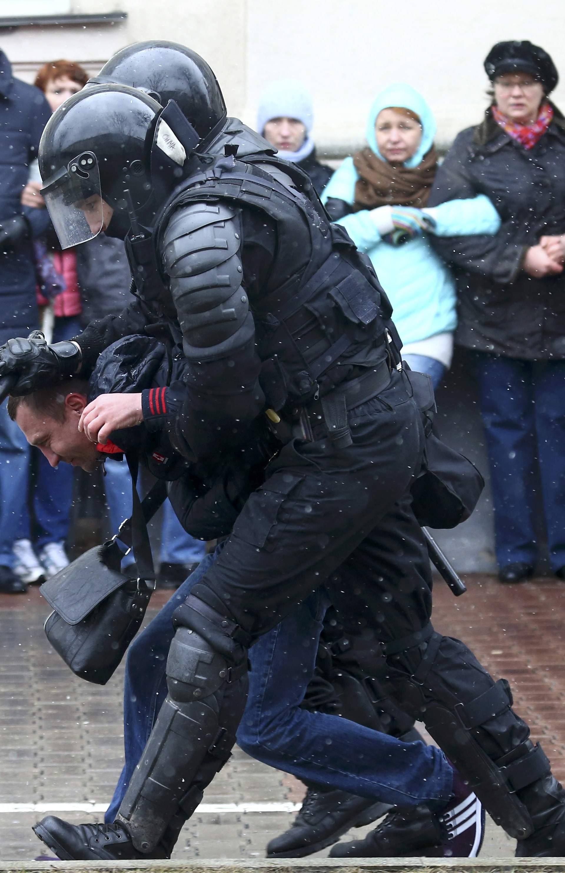 Law enforcement officers detain a man during a gathering which marks the anniversary of the proclamation of the Belarussian People's Republic in Minsk