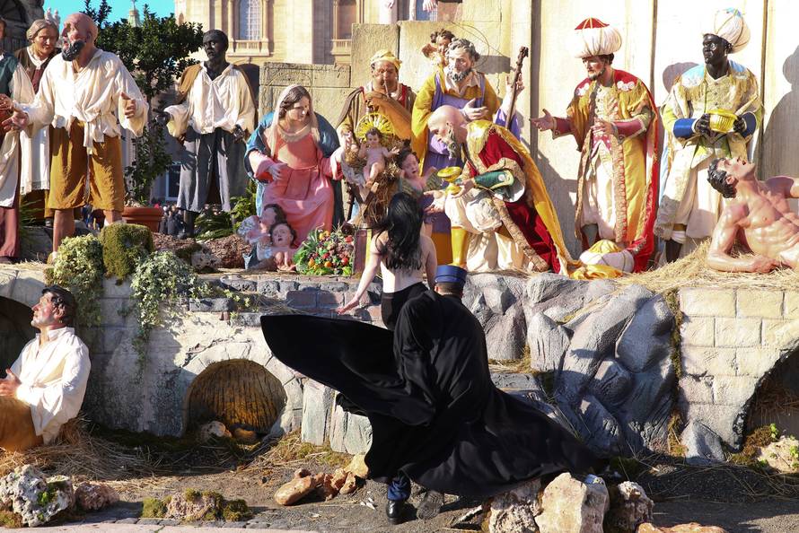 A Vatican gendarme attempts to block a topless activist of women's rights group Femen, who tries to reach the Nativity scene in Saint Peter's square at the Vatican