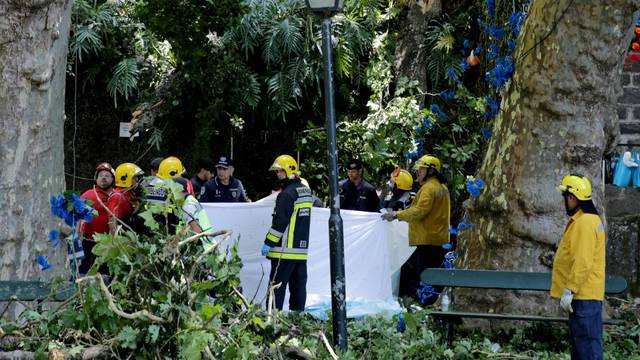 Firefighters cover victims of a tree that toppled into worshipping crowds during a religious festival in Funchal