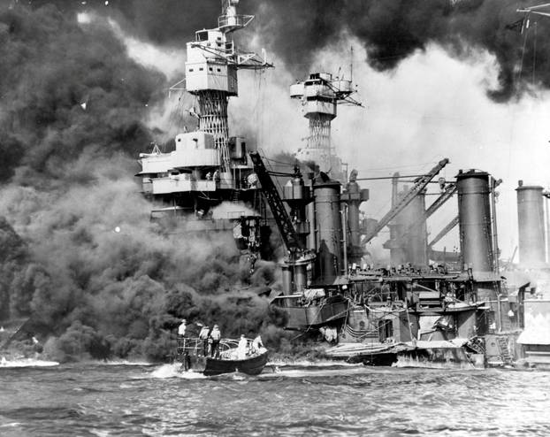 Archive photo of sailors in a motor launch rescuing a survivor from the water alongside the sunken USS West Virginia in Pearl Harbor