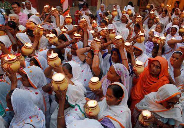 Widows carry earthen lamps as they gather inside a temple to celebrate Diwali, organised by non-governmental organisation Sulabh International in Vrindavan