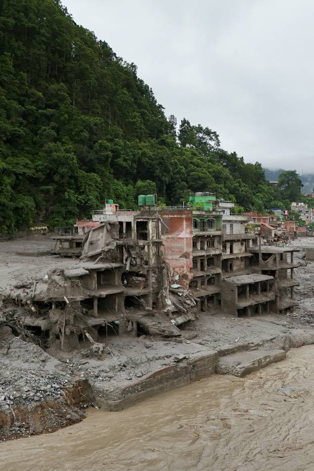 A drone view shows mud covering properties following a flash flood in Trishuli