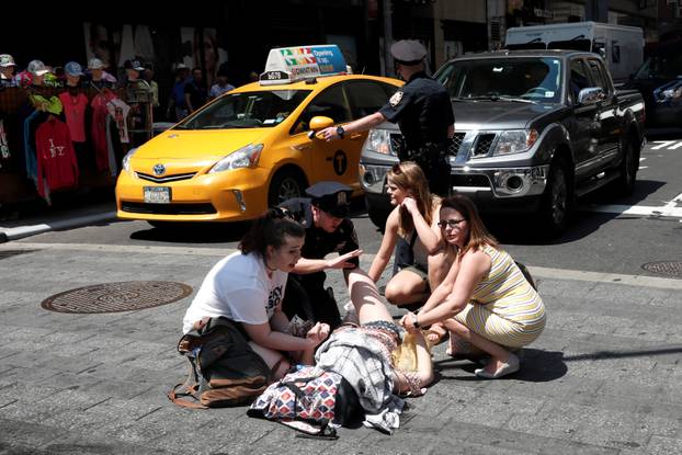 An injured woman is seen at a crosswalk in Times Square after a speeding vehicle struck pedestrians on the sidewalk in New York City