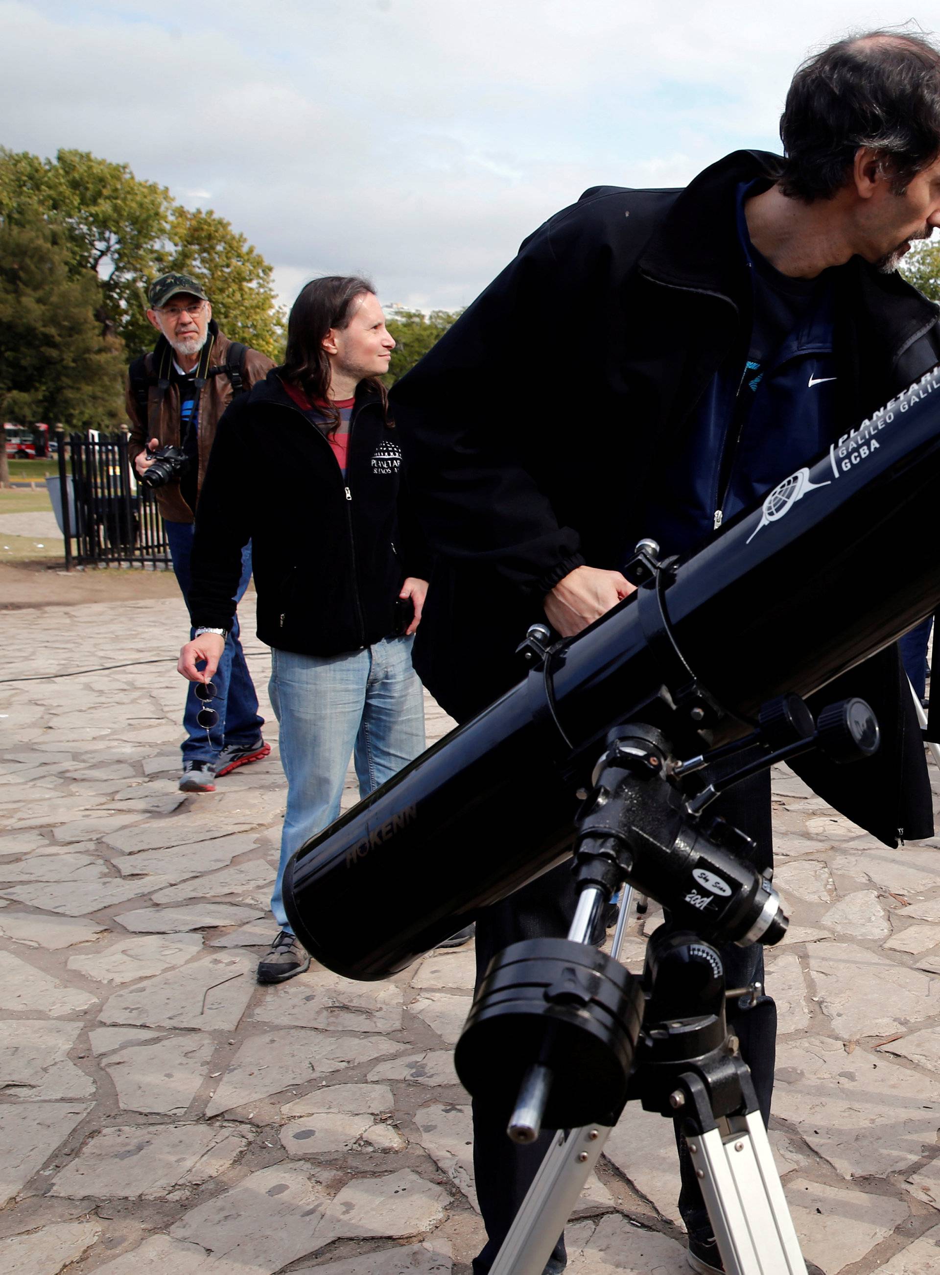 A man points to where Mercury planet is on a reflection of the sun made with a telescope outside Buenos Aires' planetarium