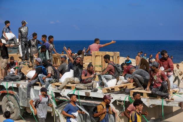 Palestinians gather to receive aid supplies amid a hunger crisis, in Beit Lahia