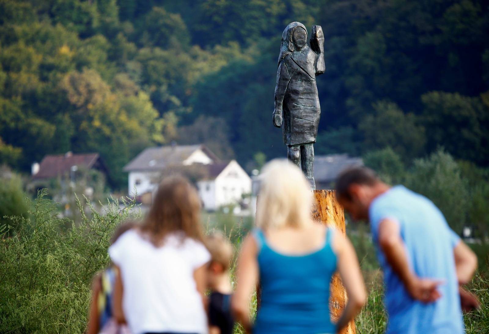 People look at the new bronze statue of U.S first lady Melania Trump in Rozno, near her hometown of Sevnica