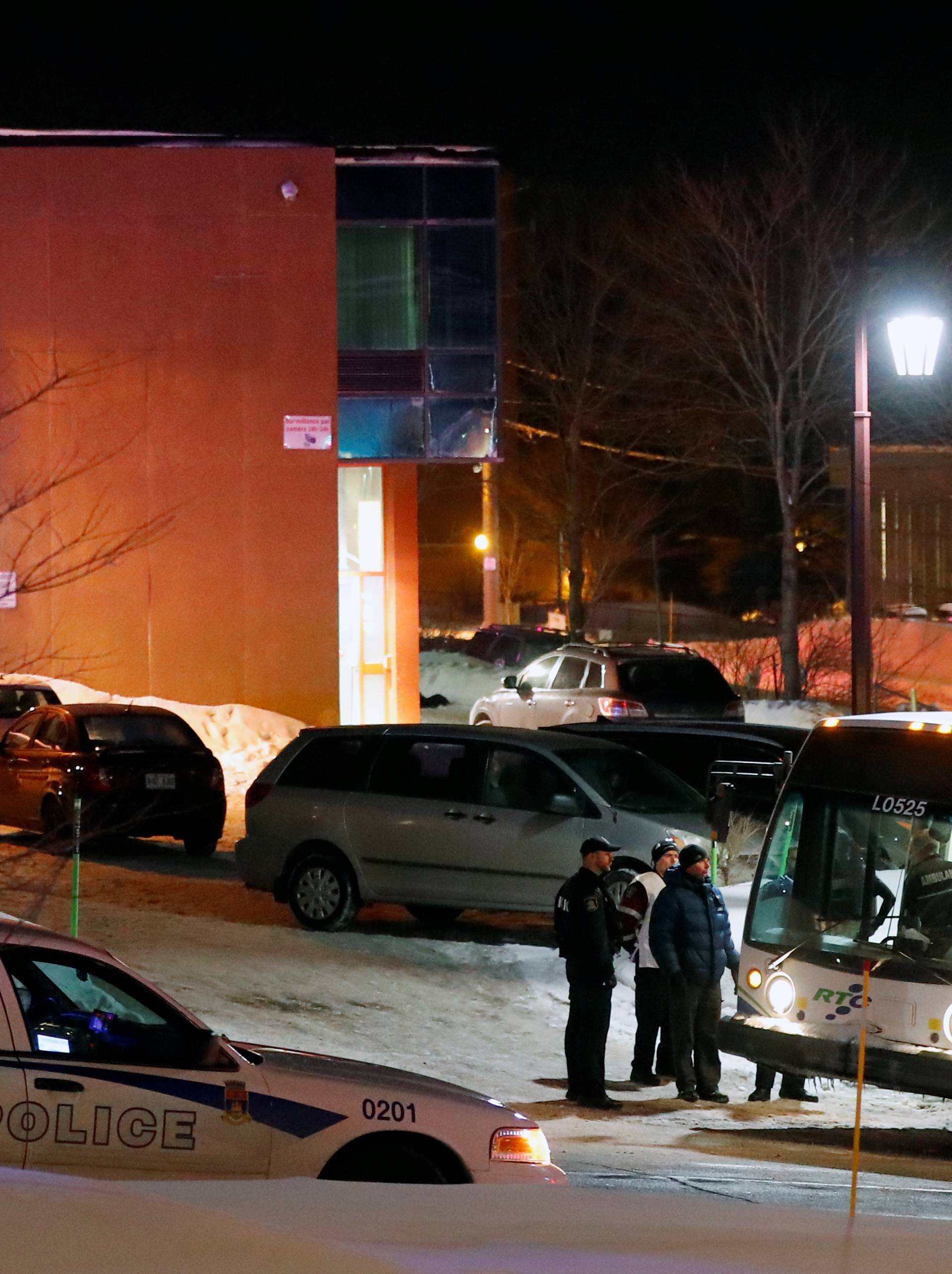 Police officers speak near a mosque after a shooting in Quebec City