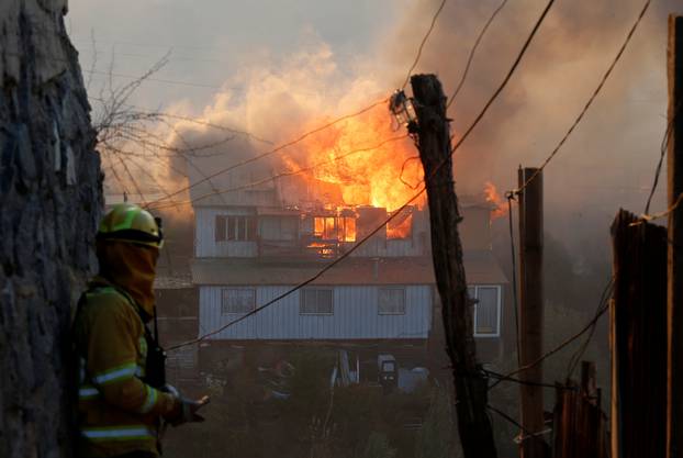 A house burns following the spread of wildfires in Valparaiso