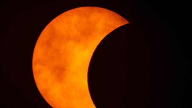 A photo shows a partial solar eclipse observed in Bangkok