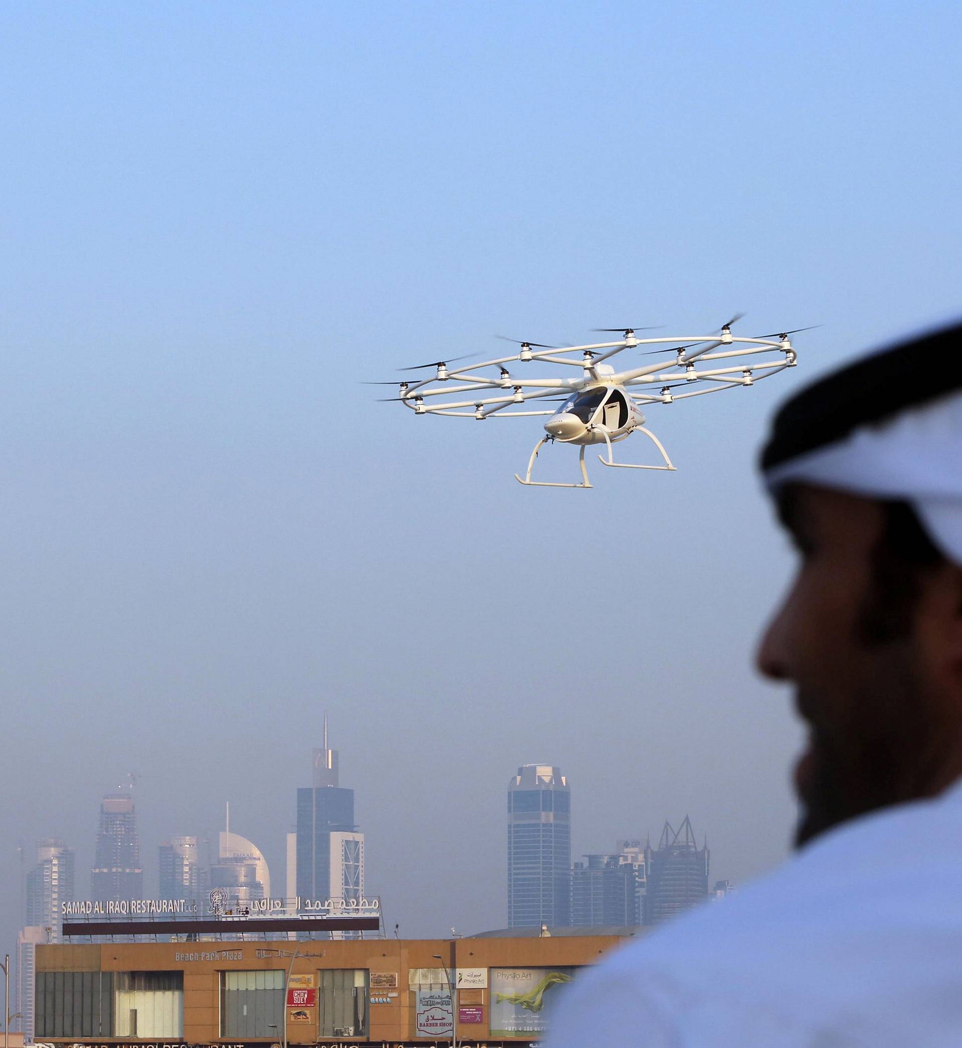 A man looks on as the flying taxi is seen in Dubai