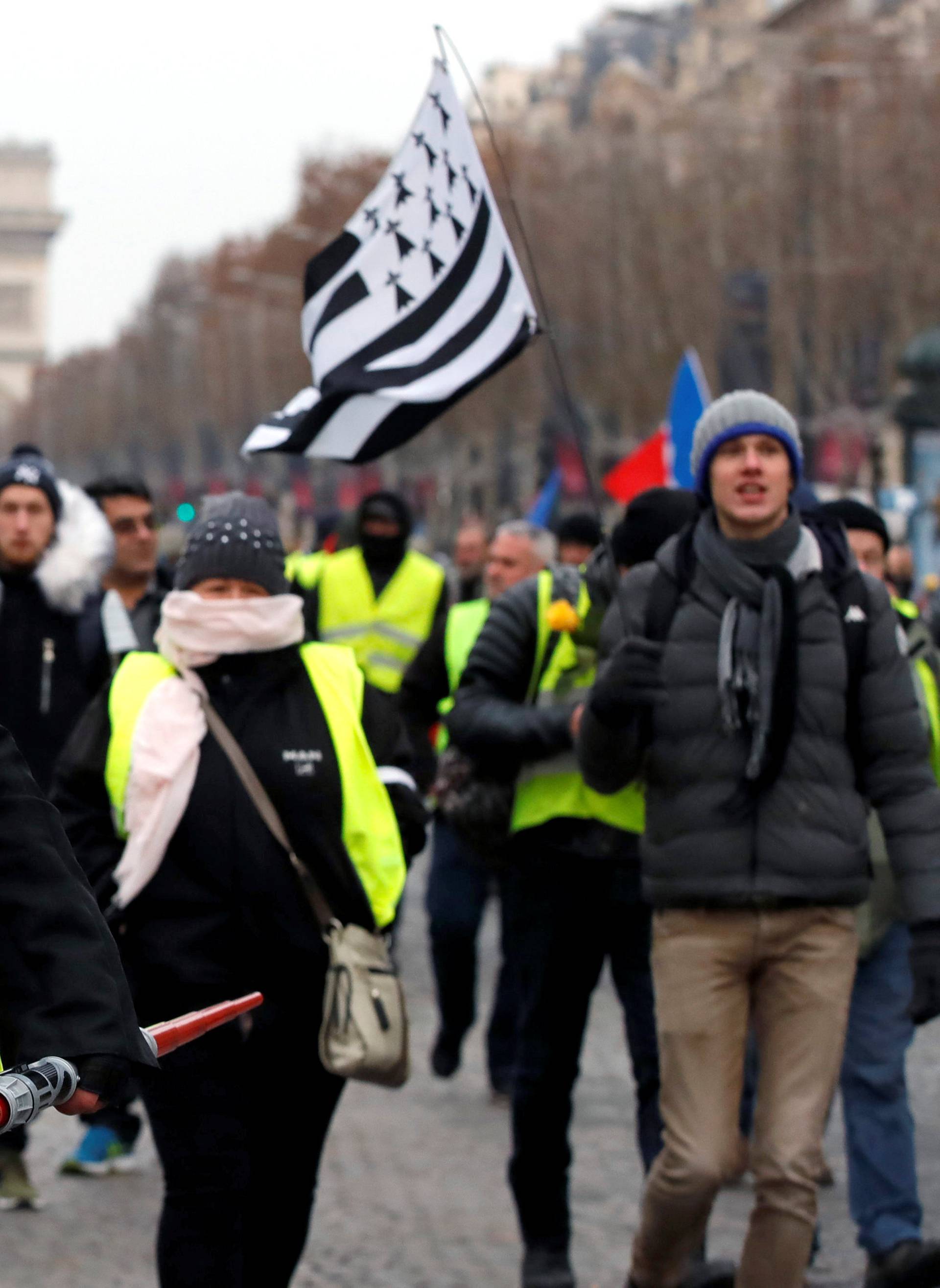 A protester wearing a yellow vest and an Anonymous mask takes part in a demonstration by the "yellow vests" movement in Paris
