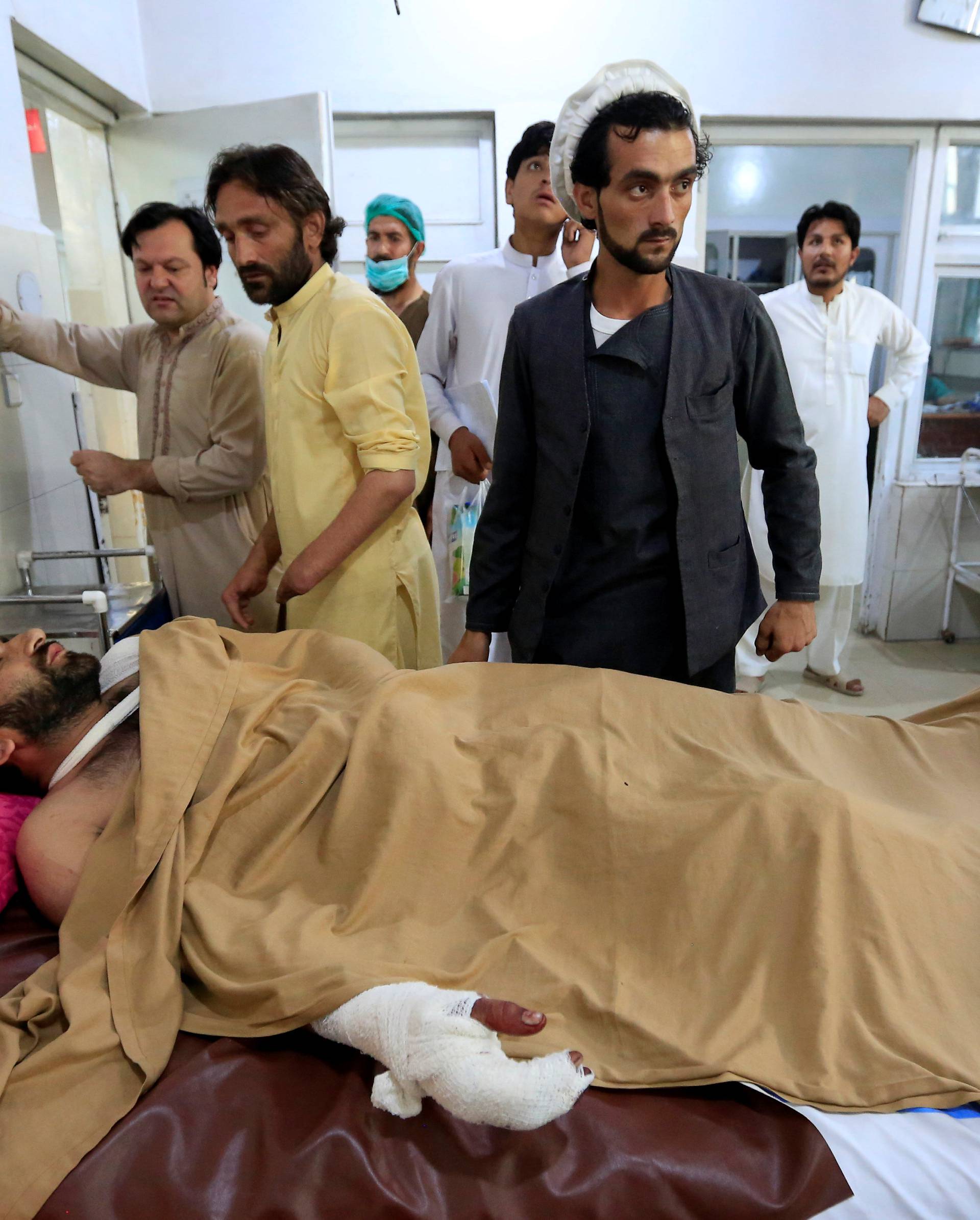 An injured man receives treatment in a hospital, after blasts at a sports stadium, in Jalalabad city, Afghanistan