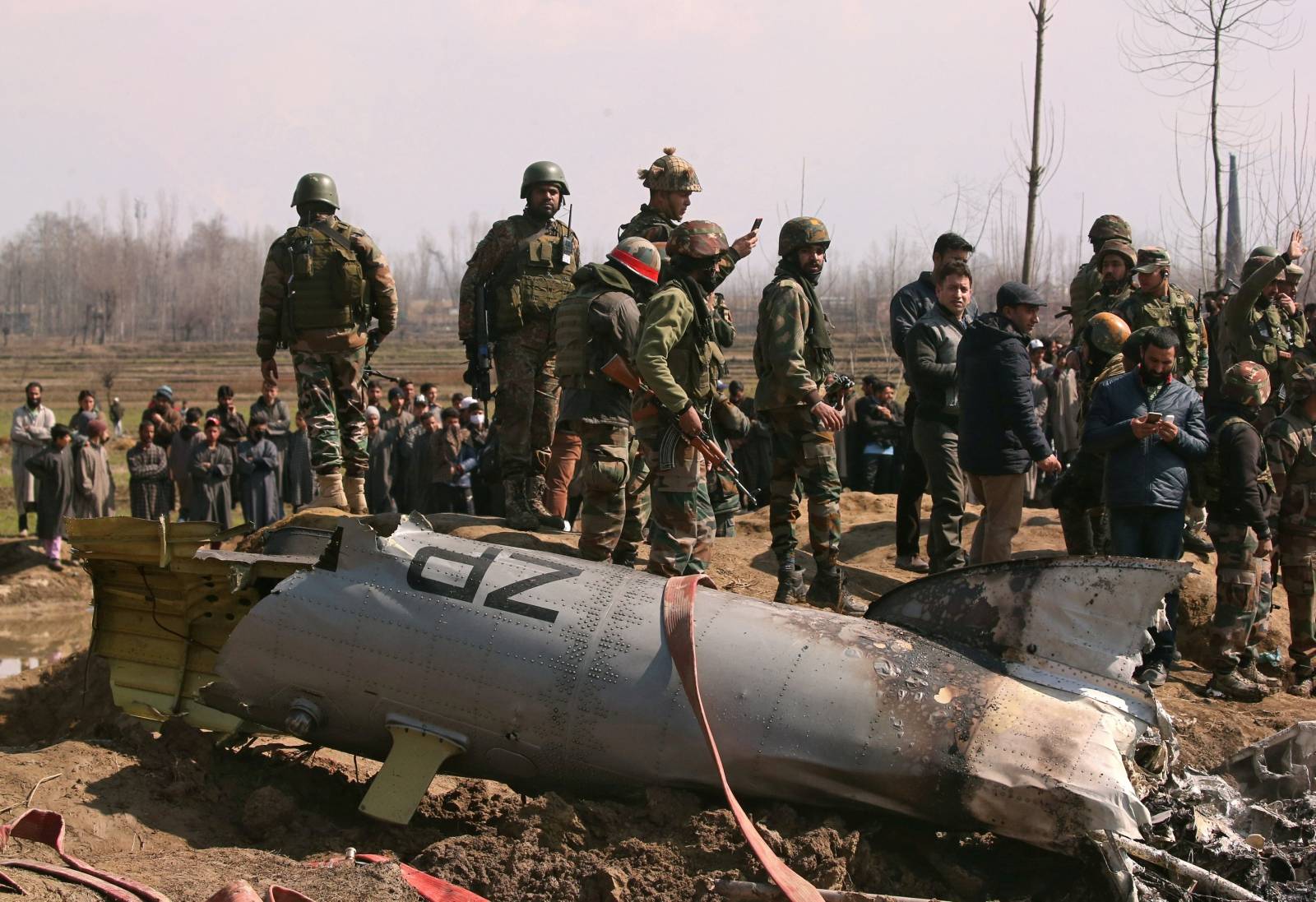 Indian soldiers stand next to the wreckage of IAF helicopter after it crashed in Budgam district