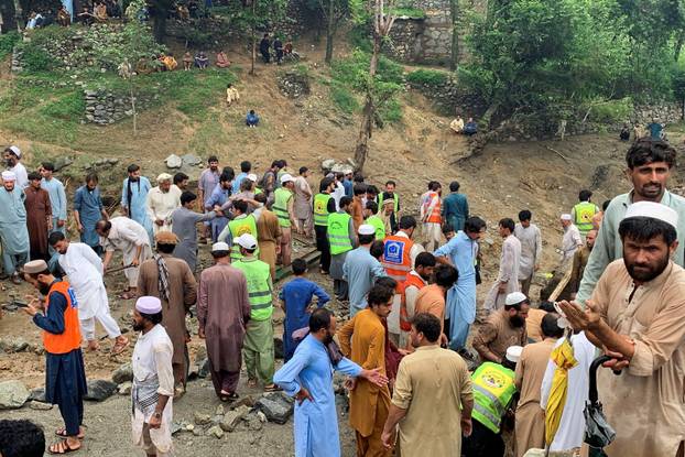 Rescue workers and residents gather after cloudburst following heavy rains and flooding, in Jibrari village in Salarzai Tehsil
