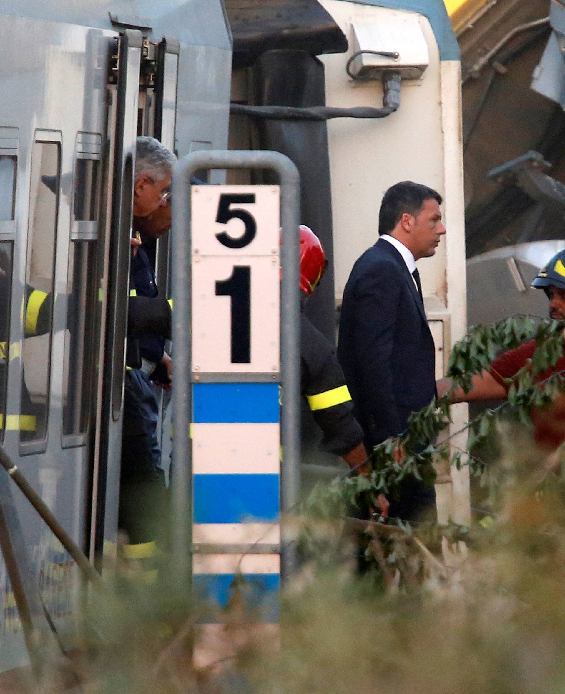 Italian Prime Minister Matteo Renzi walks at the site where two passenger trains collided in the middle of an olive grove in the southern village of Corato