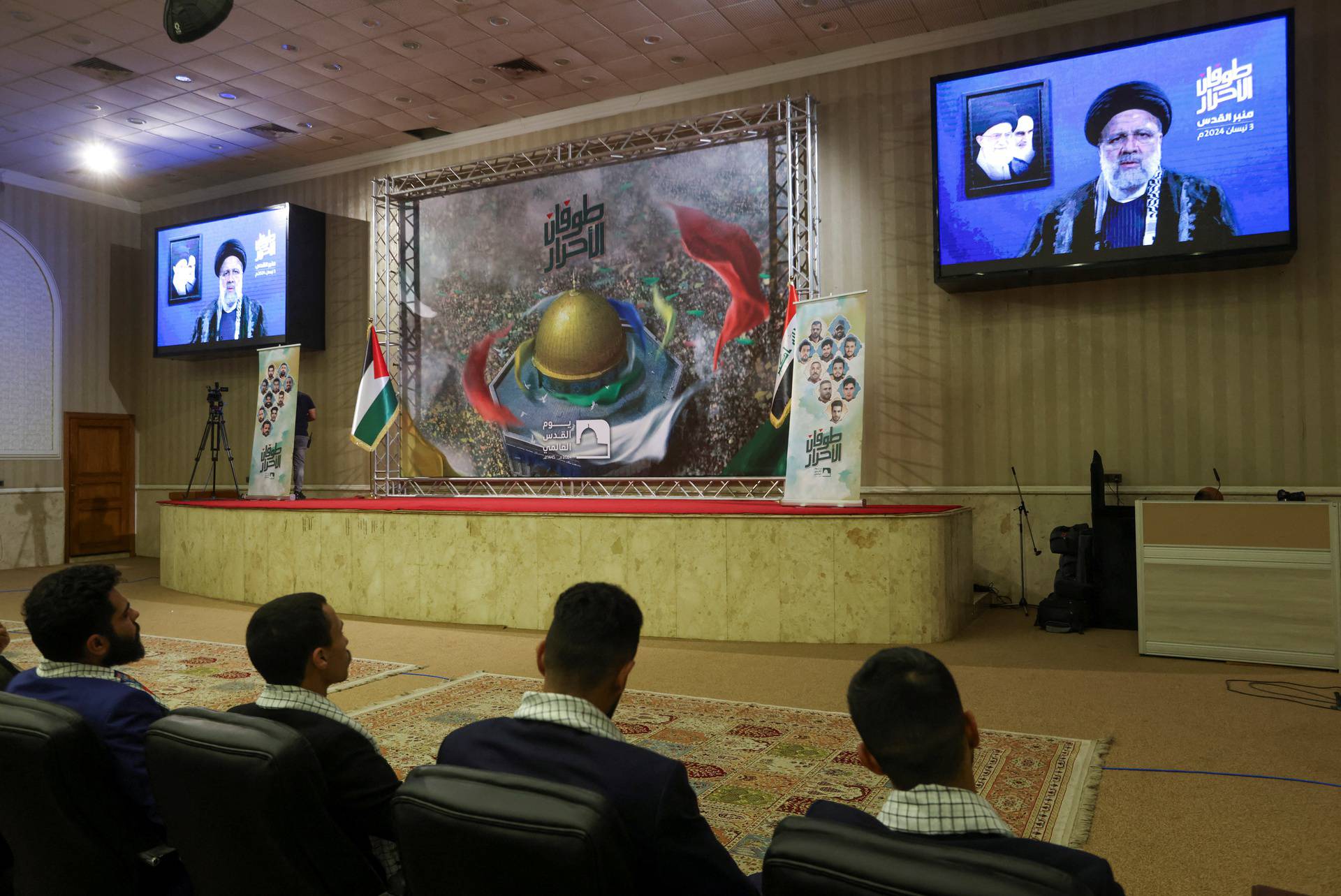 Supporters of Iraqi Shi'ite armed groups watch a televised speech by Iranian President Ebrahim Raisi, ahead of Al-Quds (Jerusalem) Day, in Baghdad