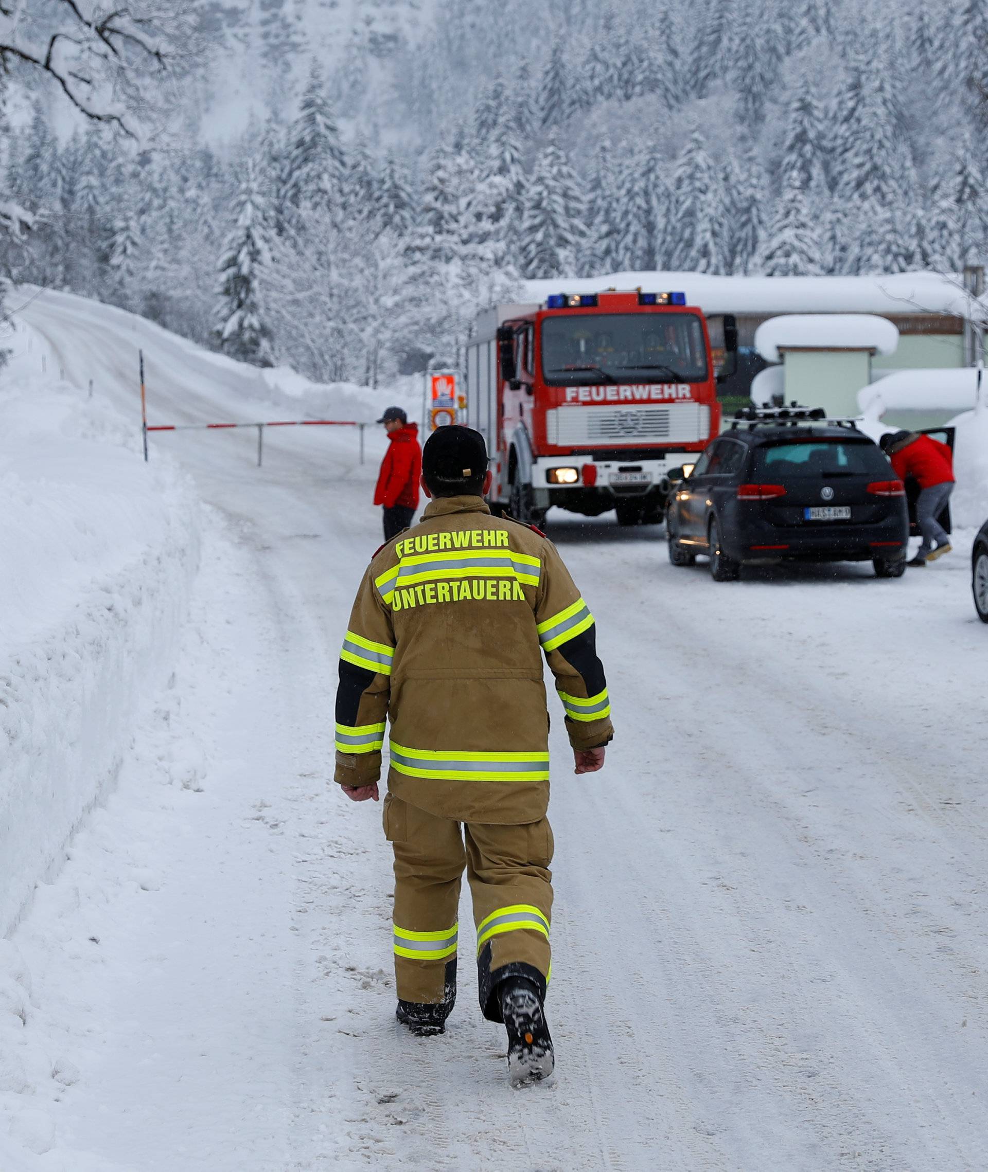 A member of the fire brigade walks on a closed road after heavy snowfall near Obertauern