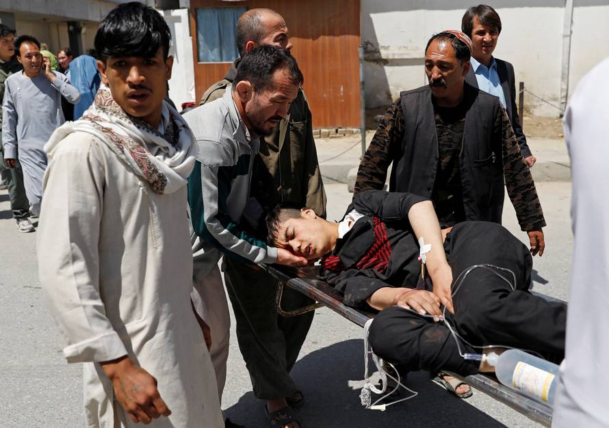 Relatives carry an injured man outside a hospital after a suicide attack in Kabul