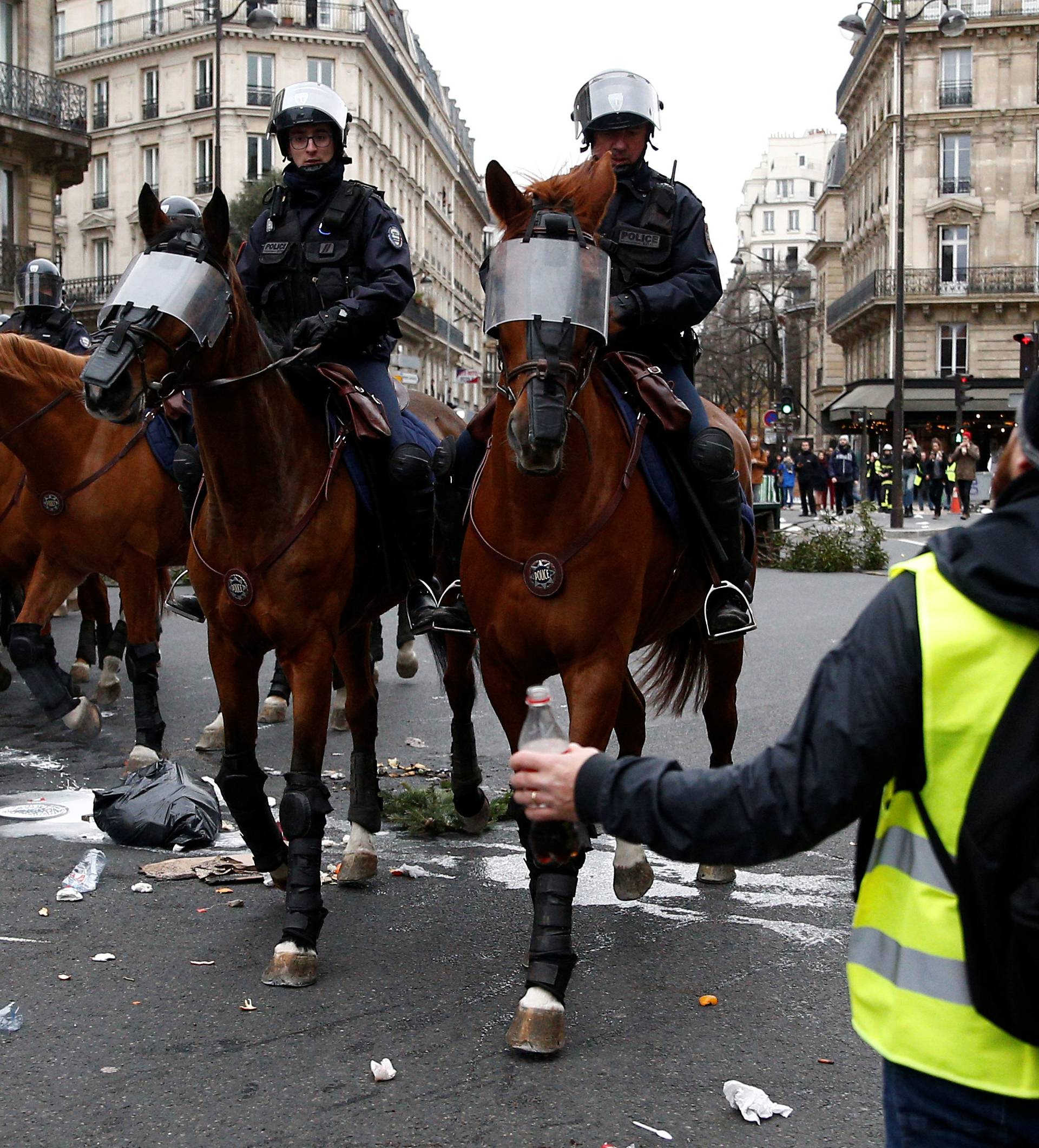 French mounted police advance during clashes with protesters wearing yellow vests at a demonstration during a national day of protest by the "yellow vests" movement in Paris
