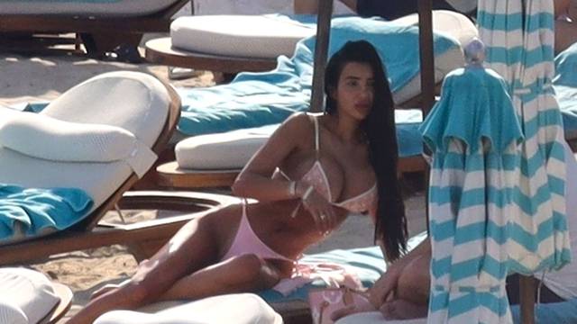 *EXCLUSIVE* the British Glamour Model Chloe Khan puts on a busty display in a tiny pink bikini with a flirty display with a mystery man on holiday in Mykonos.