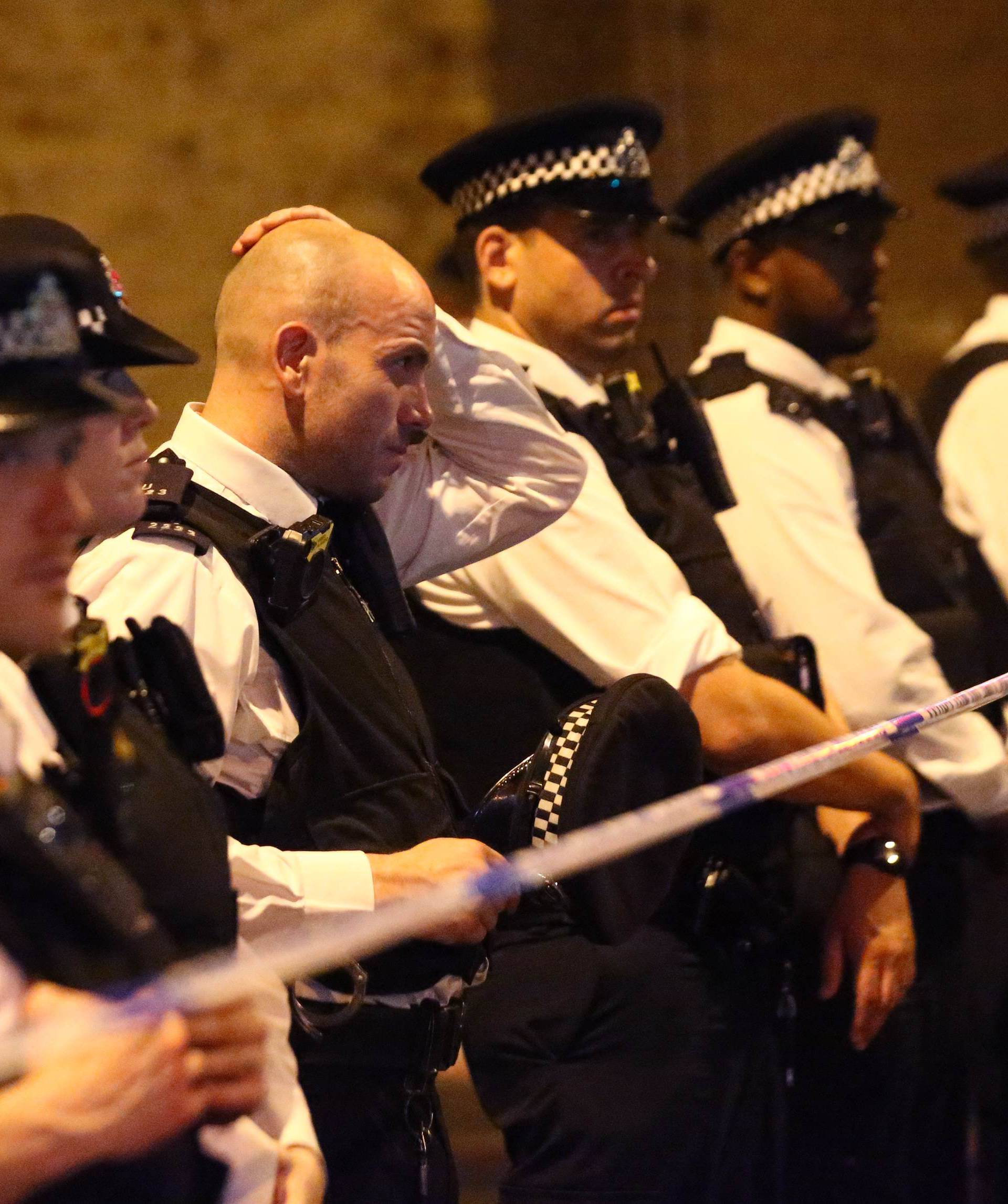 Police officers attend to the scene after a vehicle collided with pedestrians in the Finsbury Park neighborhood of North London