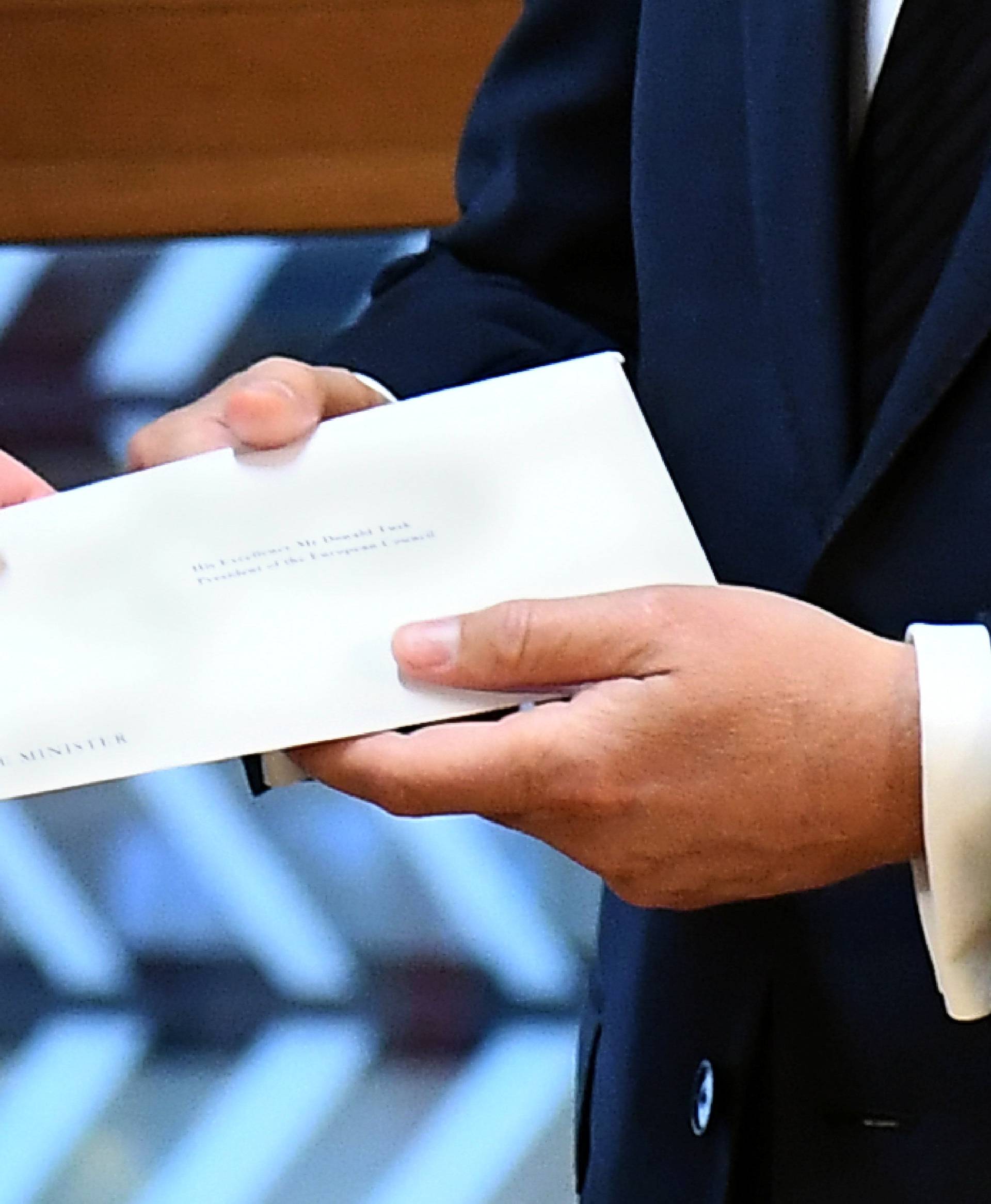 Britain's permanent representative to the European Union Tim Barrow delivers British Prime Minister Theresa May's Brexit letter to EU Council President Donald Tusk in Brussels